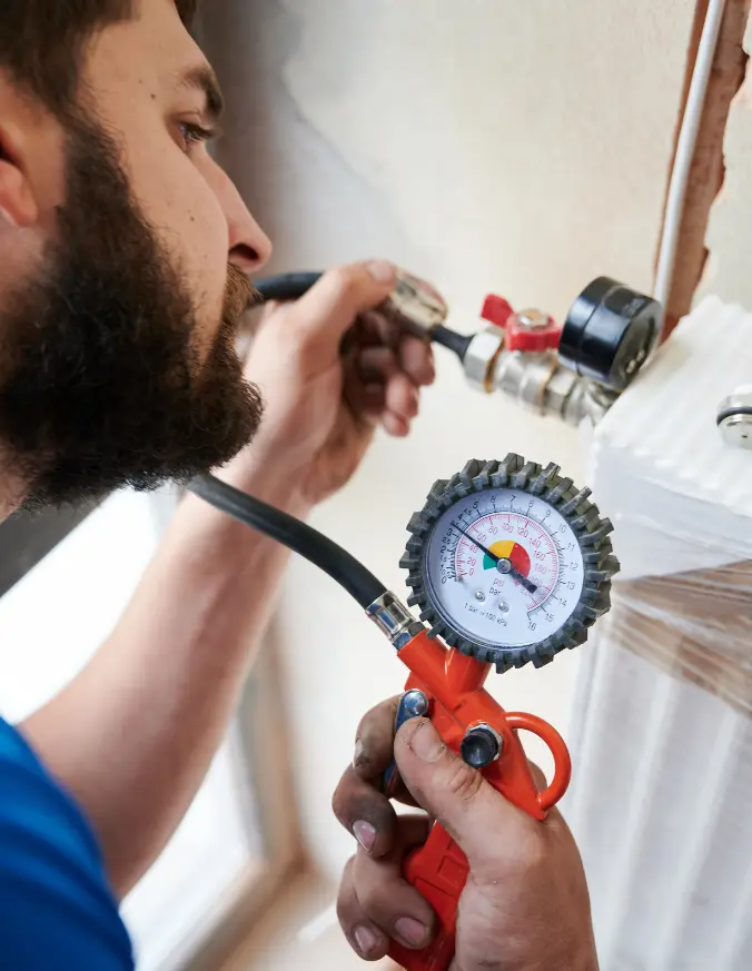 man filling pipes with pressurized air to inspect for leaks
