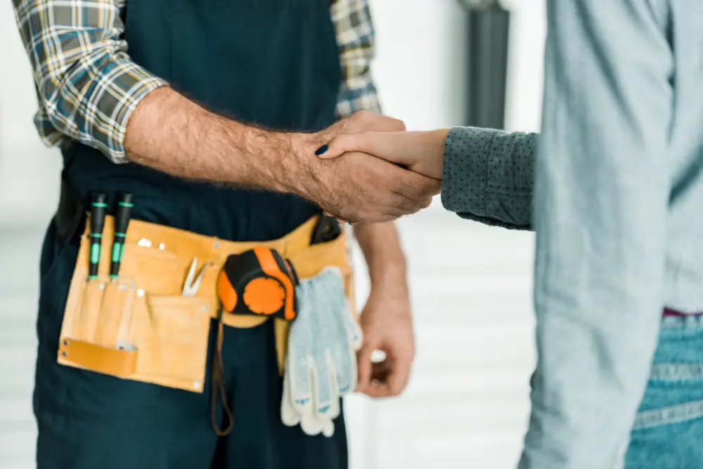 plumber and customer shaking hands in kitchen